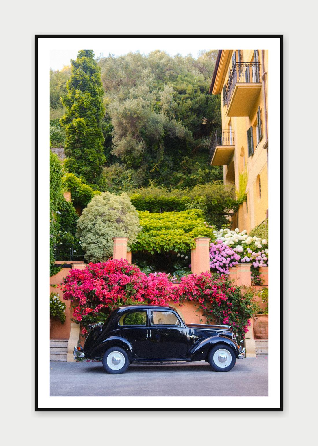 Framed print: a vintage black car beneath a flower-covered villa wall, Portofino, Italy